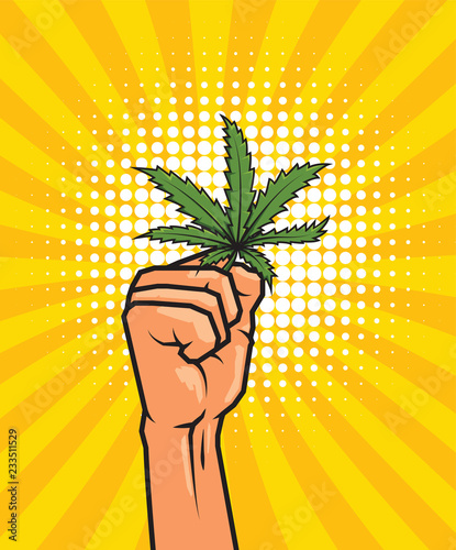 Fist held high hold on cannabis leaf.