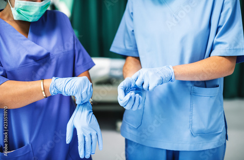Surgeons wearing gloves preparing for surgery photo