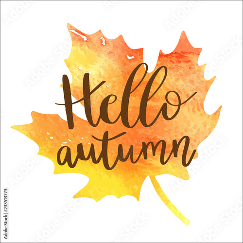 Hello autumn hand lettering phrase on orange watercolor maple leaf background.