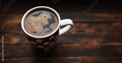black coffee in white Cup on brown background
