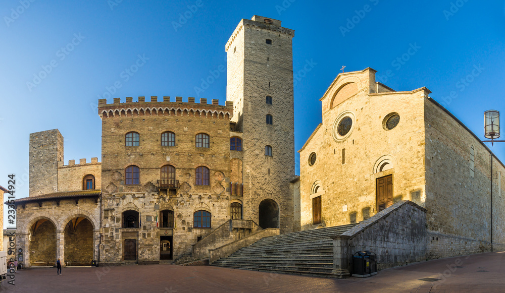 View at the Cathedral of Santa Maria Assunta with Town hall building at the Place of Duomo in San Gimignano - Italy