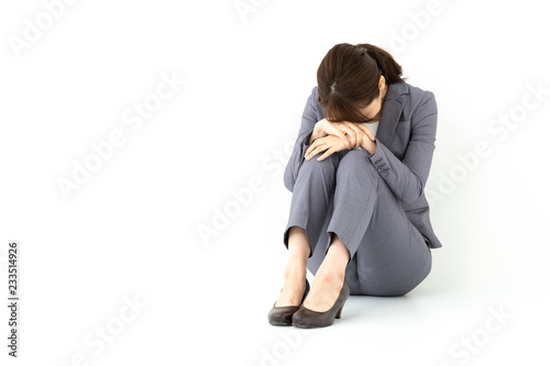 sad businesswoman sitting on white background