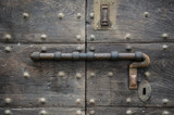 Old door with bar lock and keyhole