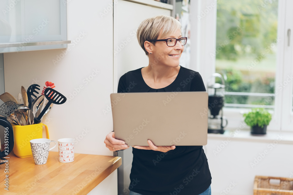 Attractive woman holding an open laptop at home Attractive woman holding an open laptop at home