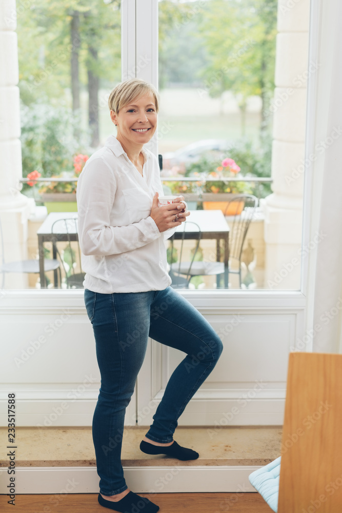 Attractive smiling housewife enjoying coffee Attractive smiling housewife enjoying coffee