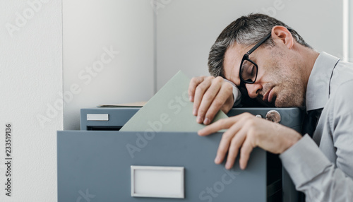 Tired office worker sleeping in the office photo