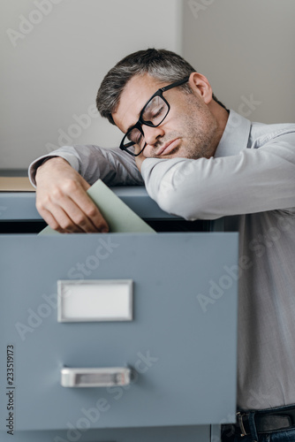 Tired office worker sleeping in the office photo