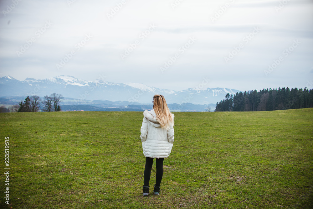 young woman in a field with views of the mountains 
