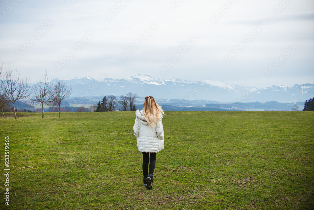 young woman in the field with mountain views in the background