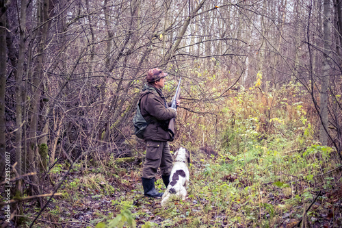 male hunter, in the forest, with arms, dog Springer Spaniel, hunting, autumn