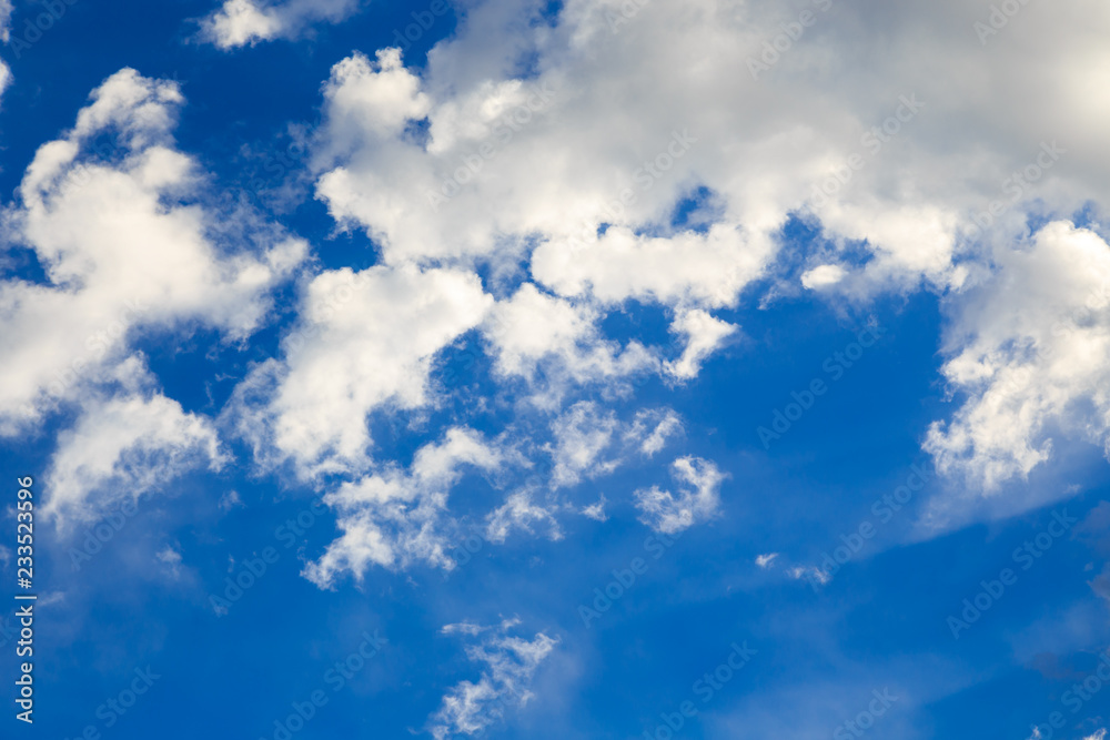 Fototapeta premium Blue sky with white cumulus clouds. Abstract natural background. Perfect summer day in the countryside.
