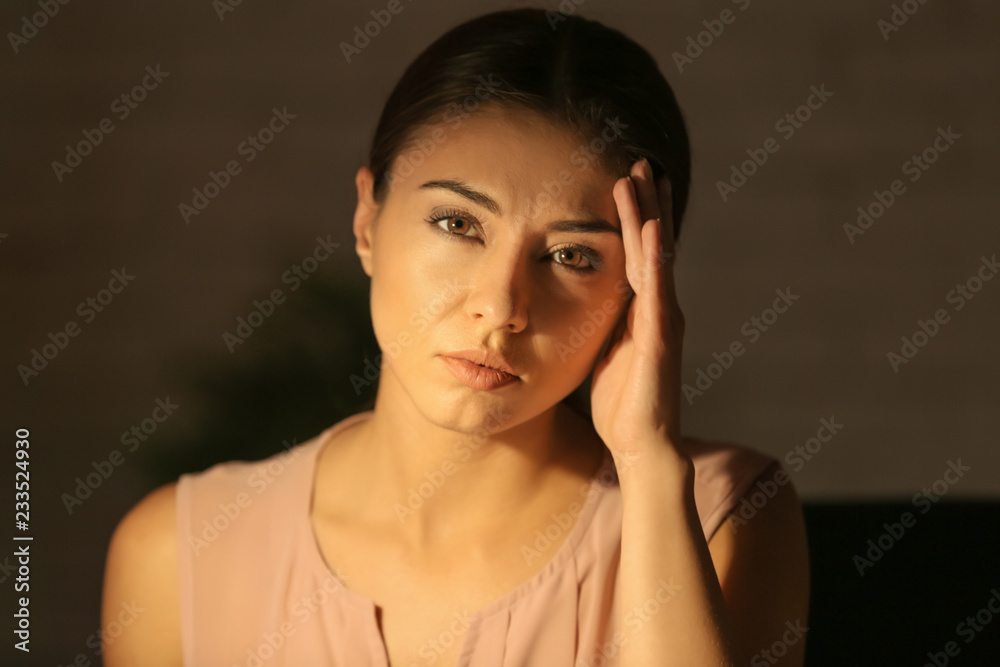 Woman suffering from headache at home late in evening Woman suffering from headache at home late in evening