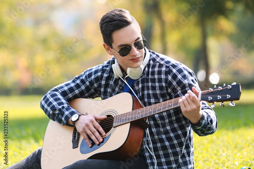 Young man playing guitar in...