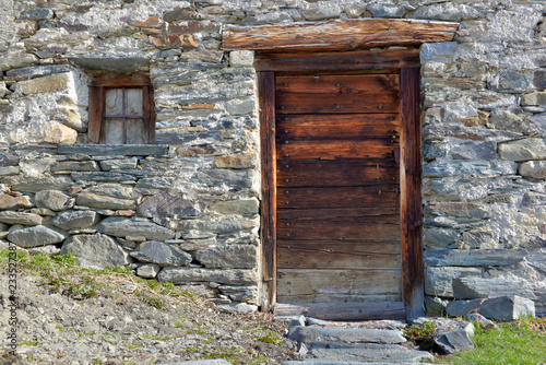 Foto wooden door and little window of an old alpine chalet