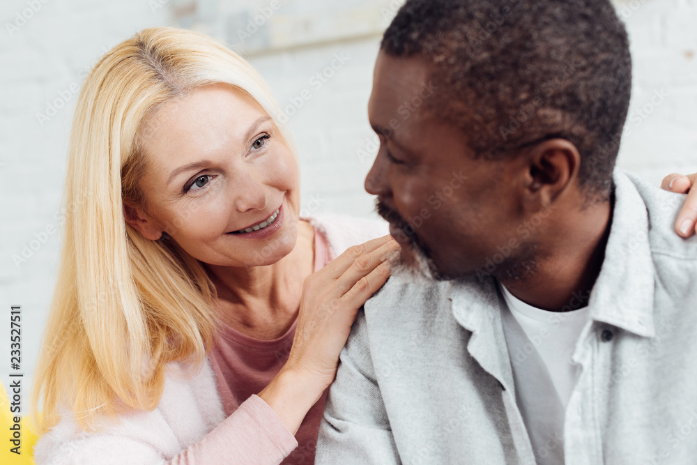 Naklejka premium close up of attractive mature woman hugging african american mature man