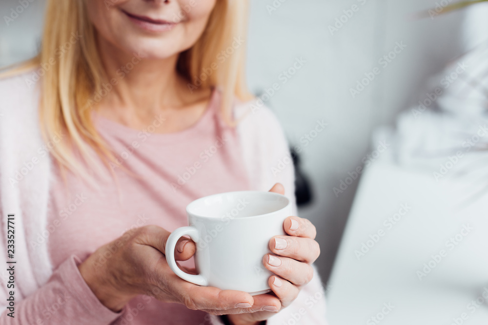 close up of mature blonde woman holding white coffee cup close up of mature blonde woman holding white coffee cup