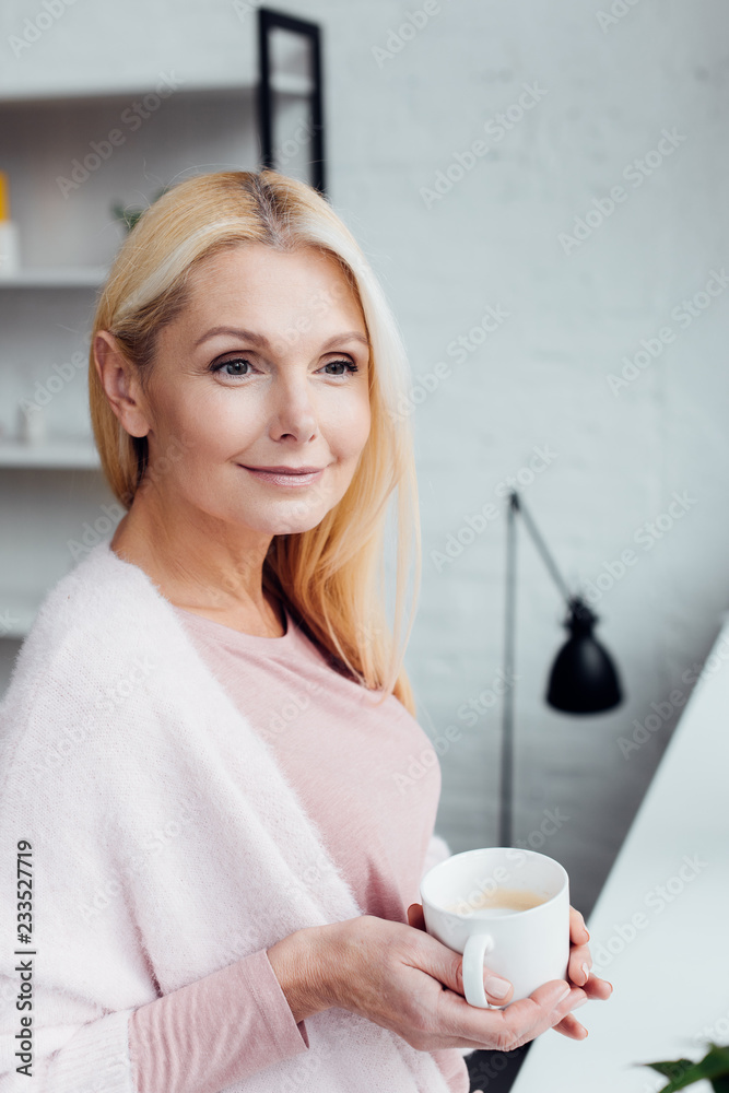 attractive mature blonde woman holding white coffee cup attractive mature blonde woman holding white coffee cup