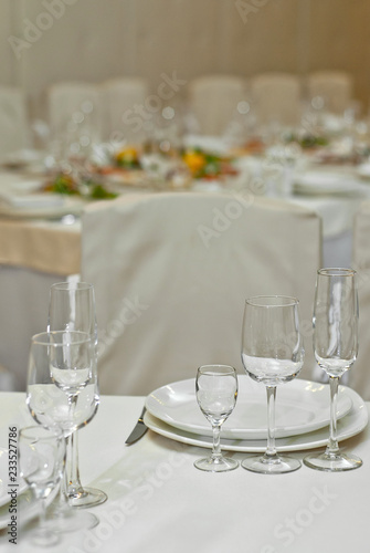 Glass dishes on a table on a white tablecloth. clean and empty. lovely, chic restaurant. cozy atmosphere. serving a banquet