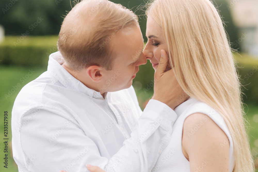 Partrait of man and woman wearing white clothes. Green background. Blond hair woman smile. Lovestory Partrait of man and woman wearing white clothes. Green background. Blond hair woman smile. Lovestory