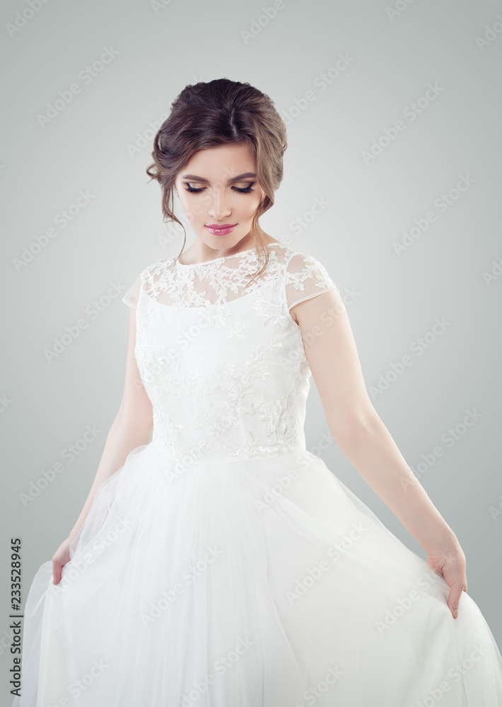 Attractive woman with bridal hairdo and makeup posing on white background Attractive woman with bridal hairdo and makeup posing on white background
