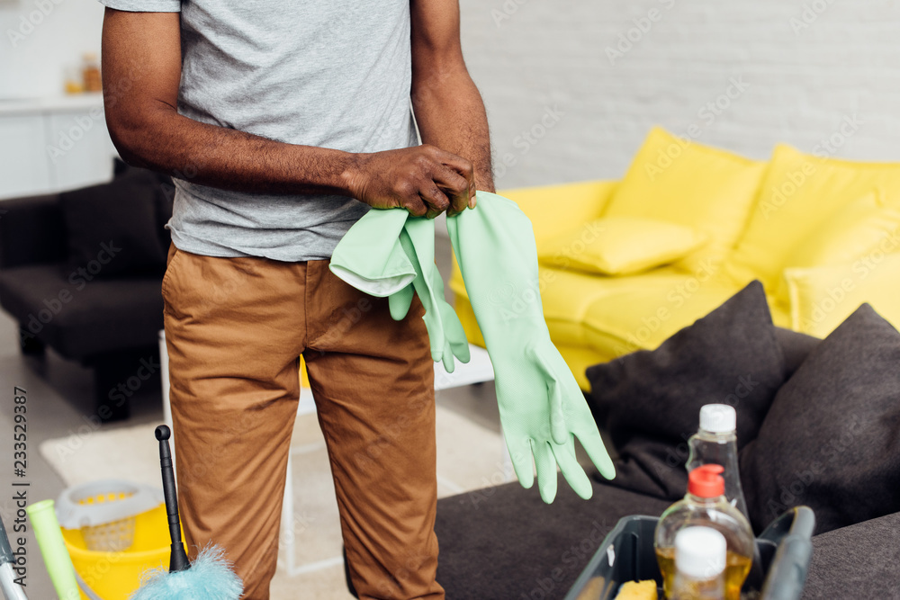 african american mature man putting on rubber gloves
