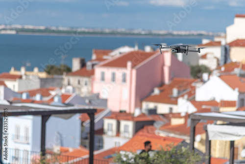 Drone in the air flying about city roofs
