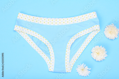 Beautiful women's panties with flowers on blue background