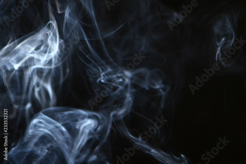 beautiful swirl contrast blue smoke against dark background.