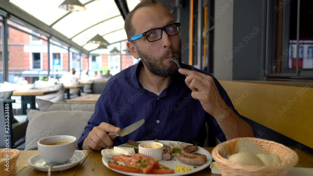 Handsome young man eating breakfast in cafe Handsome young man eating breakfast in cafe