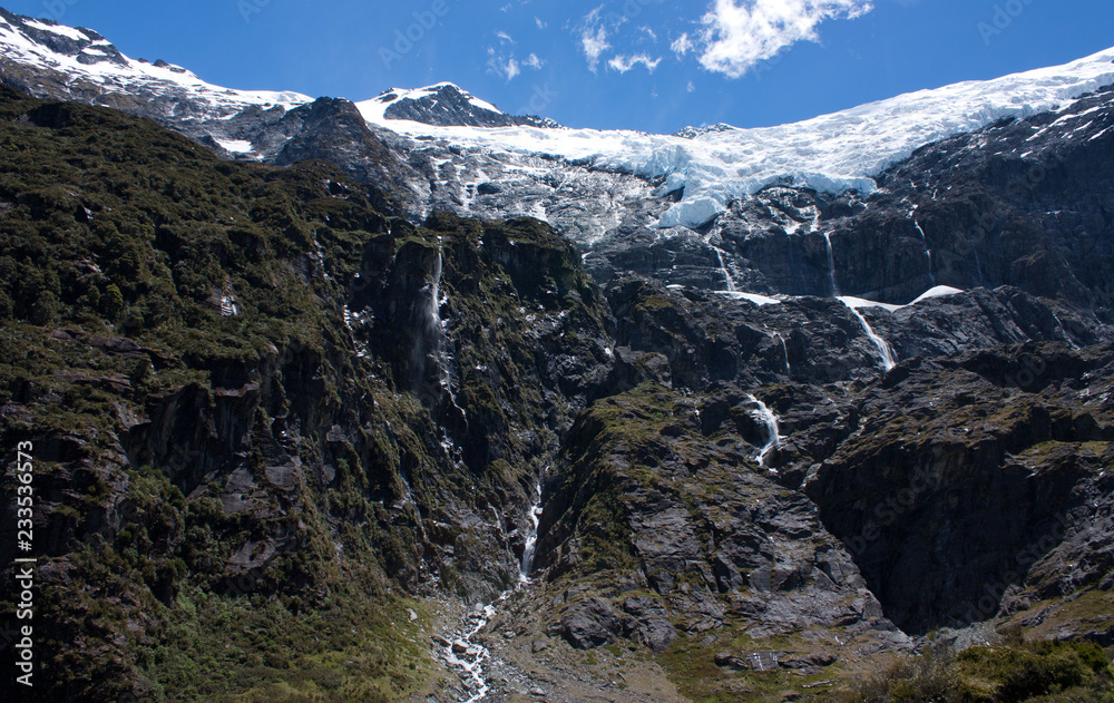 Rob Roy Glacier with waterfalls made of melting water in New Zealand