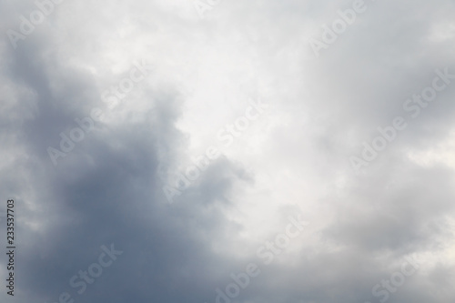 Cloudy rainy summer day. Through the rain clouds visible part of the blue sky and the rays of the sun. Summer abstract background.