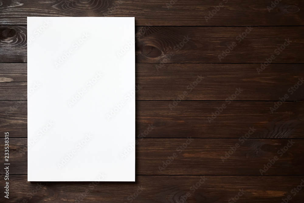 White blank canvas on brown wooden background with copy space. Mockup. Front view White blank canvas on brown wooden background with copy space. Mockup. Front view