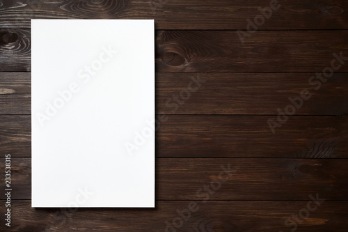 White blank canvas on brown wooden background with copy space. Mockup. Front view