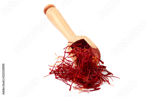 Saffron spice threads (strands) in wooden scoop isolated on white background