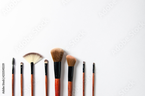 Set of professional make up brushes on light beige background. Space for your text