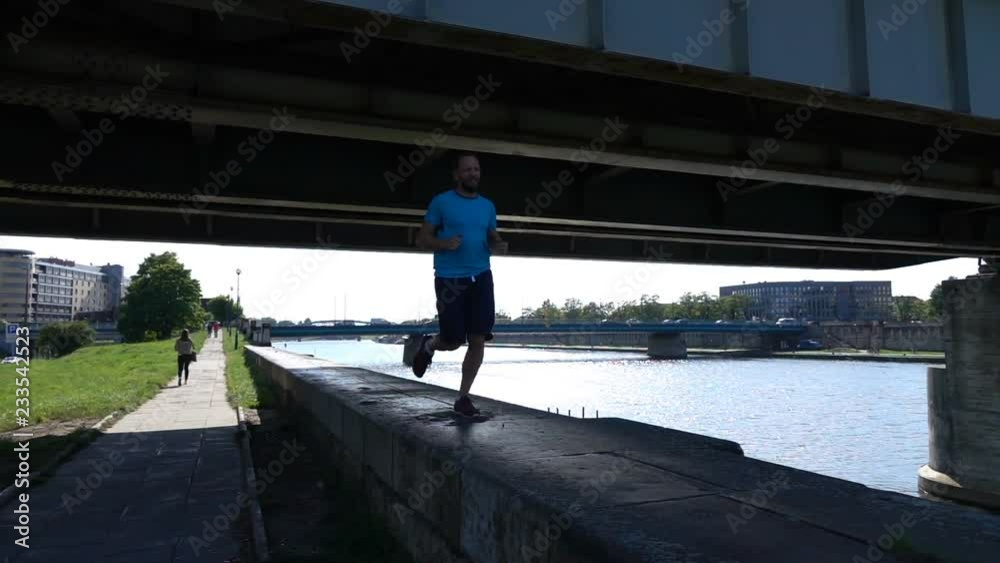 Young, sporty man jogging in the city, super slow motion Young, sporty man jogging in the city, super slow motion