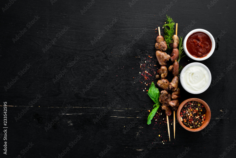 Skewers of chicken heart. On a wooden background. Top view. Free space for your text.