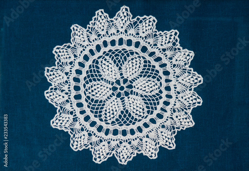 Vintage white lace napkin on blue background