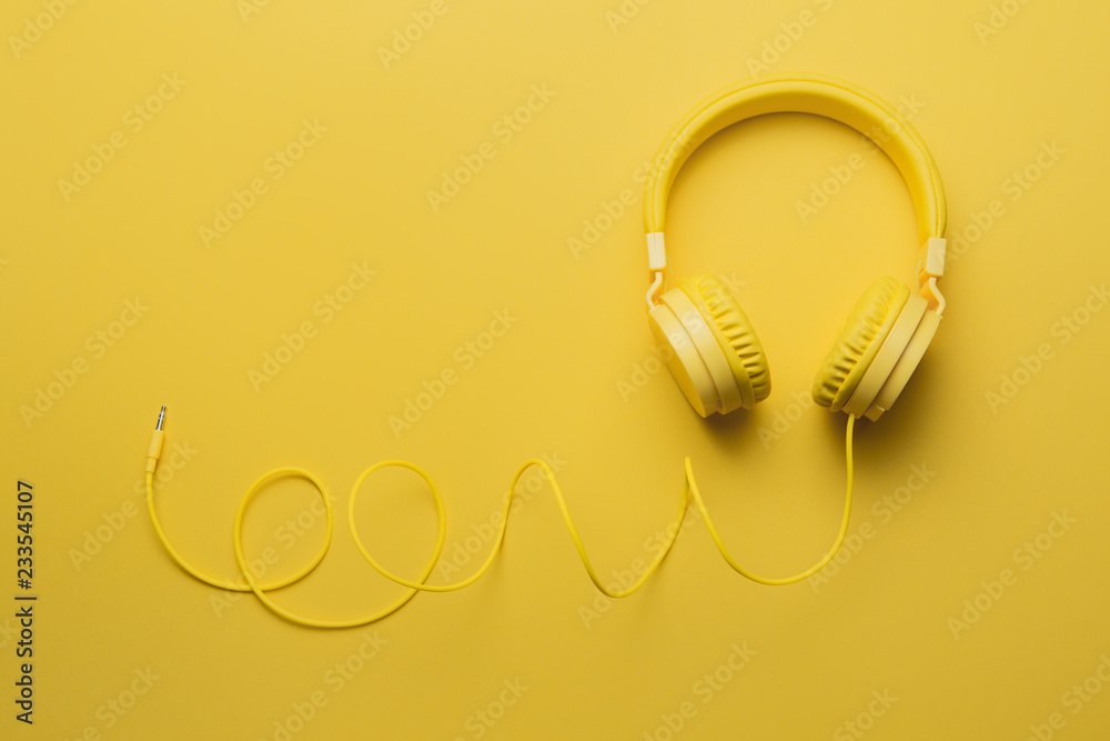 Yellow headphones on yellow background. Music concept. Yellow headphones on yellow background. Music concept.