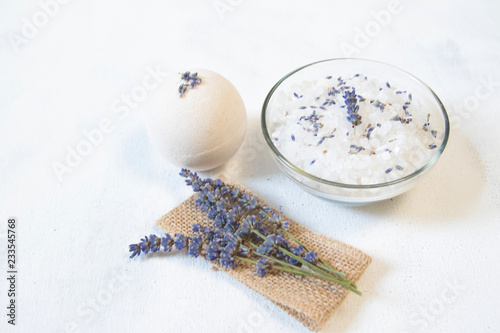 Natural herbal sea salt with aromatic lavender - perfect for relaxation. Cosmetic jars and bottles with salt, lavender flowers, bath bomb