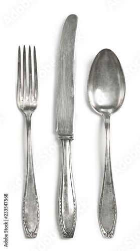 Vintage cutlery, silverware. Old silver cutlery, isolated on white background. Top view of table knife, fork and spoon with ornament details.
