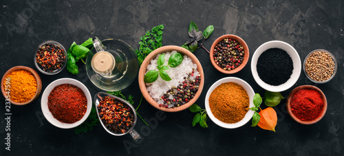 A set of spices and herbs on a stone table. Indian traditional spices. Top view. Free copy space.