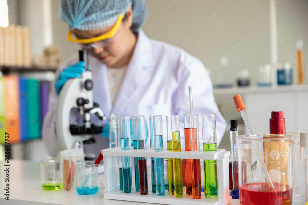 Asian female scientist working with microscopes at laboratory Asian female scientist working with microscopes at laboratory