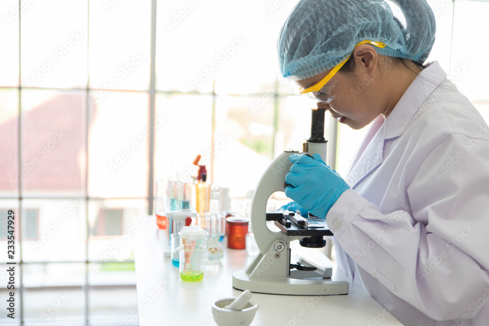 Fototapeta premium Asian female scientist working with microscopes at laboratory