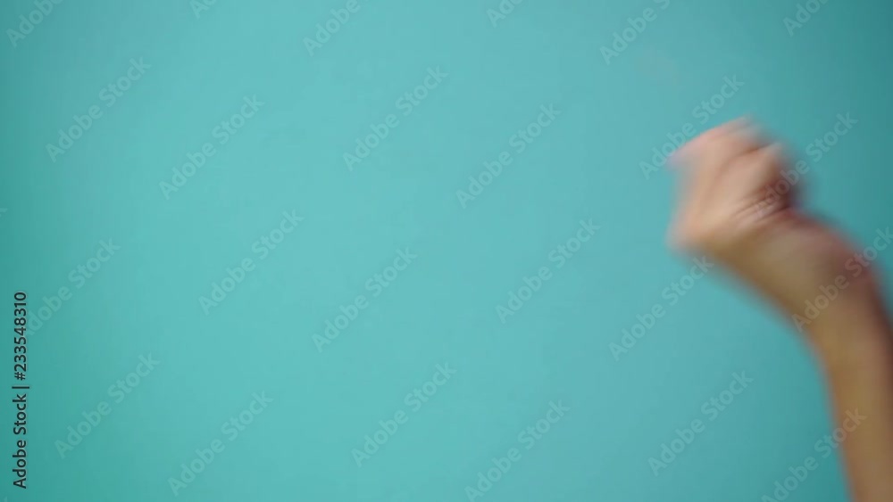 Closeup side view of one beautiful adult female hand with pink manicure appears holding something virtual and invisible isolated on green background. Real time full hd video footage.
