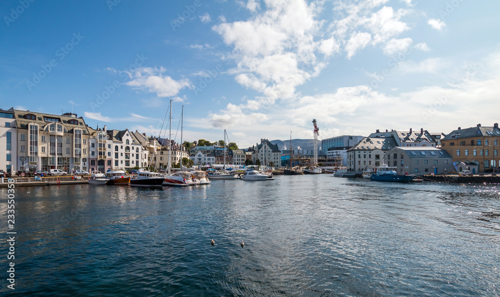 View on the center city of Alesund with historic houses, boats and people. Norway