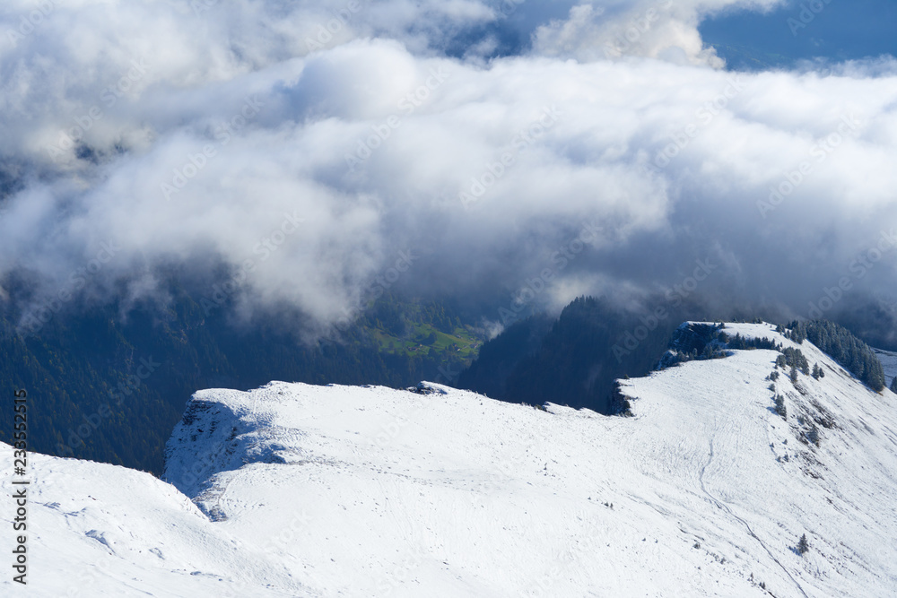 First snow and winter mountain landscape in mid october with clouds in the valley. Jungfrau region in Switzerland.
