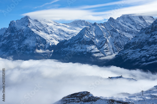 Mountain peaks above the clouds in the valley. Jungfrau region in Switzerland.