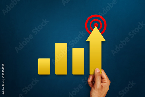 Businessman is holding arrow pointing up with graph as a symbol of growth and success or rising successful development and business development in the future
