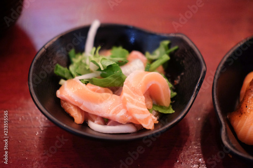 Salmon sashimi spicy salad on black dish